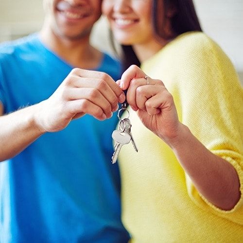Young couple showing key from new house